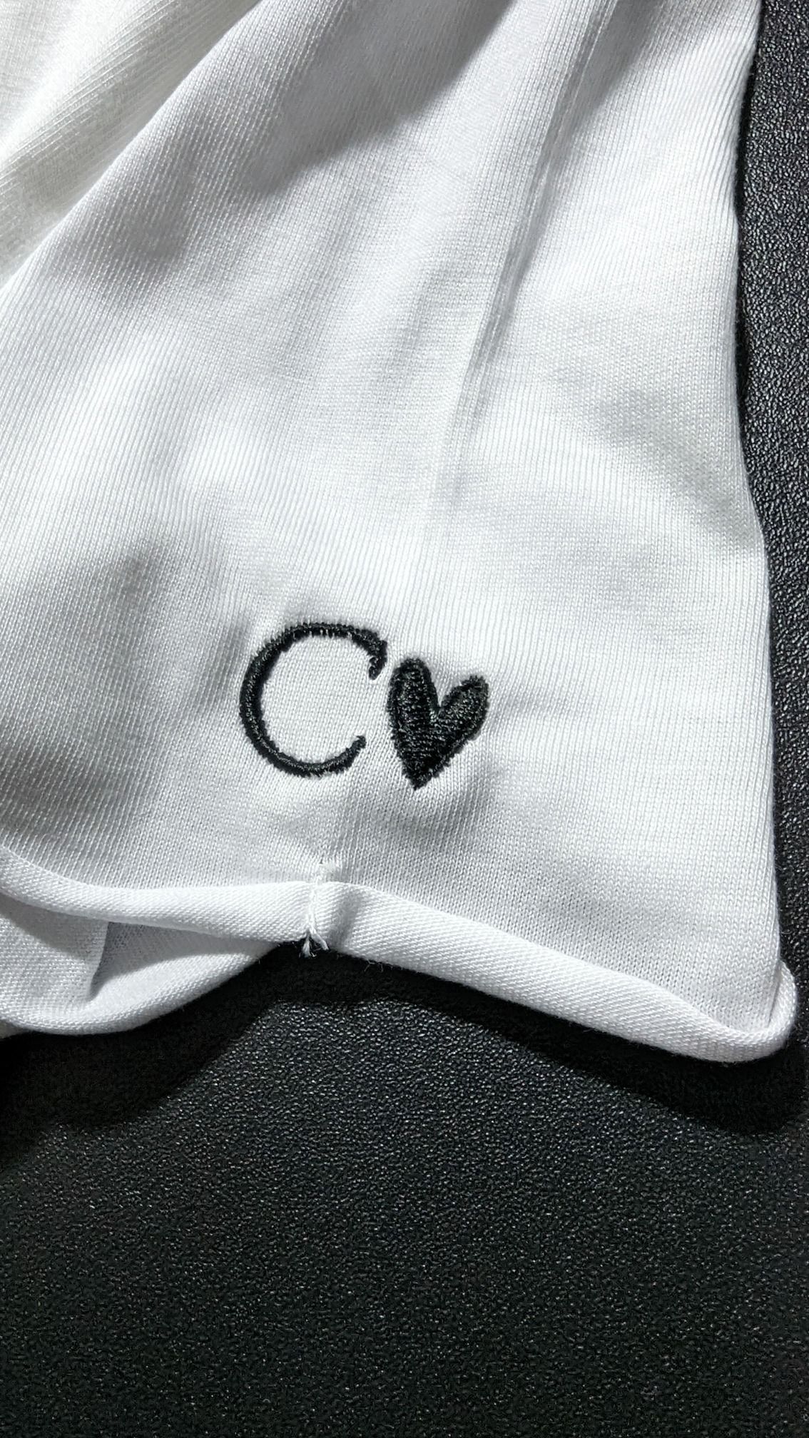 Kleine Logo-Stickerei auf weißem Textil – Stoff³ Kassel